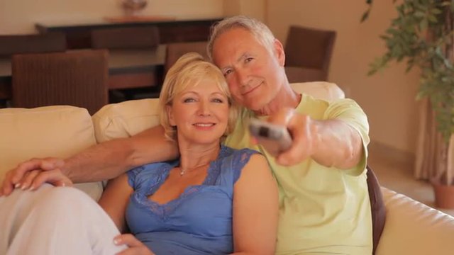 senior couple on sofa watching TV