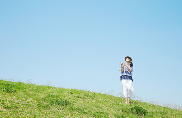 丘で指差す女性