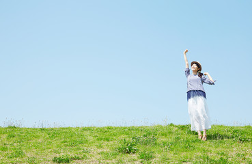 丘に立ってリラックスする女性