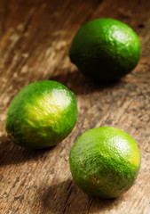 Fresh limes on an old wooden table, selective focus