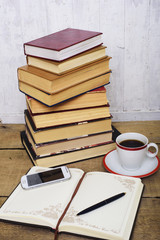 books, notepad, cellphone and coffee cup on wooden background. Education concept