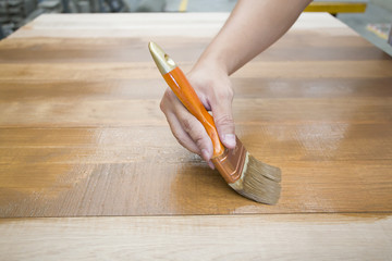 Applying protective varnish on a wooden furniture