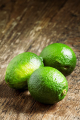 Fresh limes on an old wooden table, selective focus