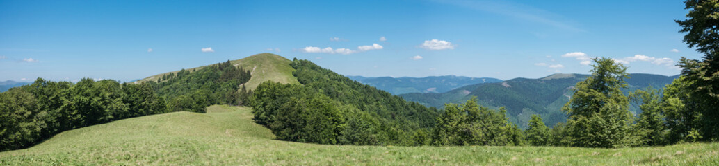 Panoramic view of spring mountains under blue sky