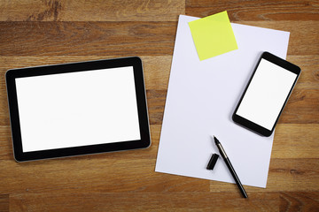 Top view on office desk with tablet, smartphone, paper and pen.