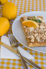 Waffles with meringue, lemon curls and orange slices