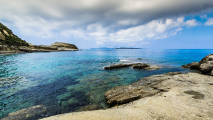 Obraz premium Shore of Ionian sea with flat rocks on the beach