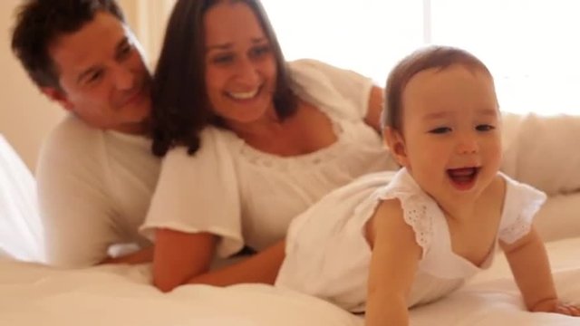 Family and baby in bed