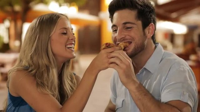 young couple in cafe, girl feeding man
