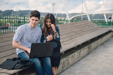 Couple using and looking a laptop