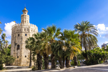 Fototapeta na wymiar Torre del Oro in Sevilla inmitten von Palmen