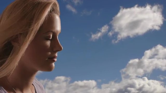 Woman's face with clouds in the background. 