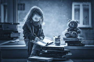 Adorable little girl, writing letter to Santa, sitting on a wind