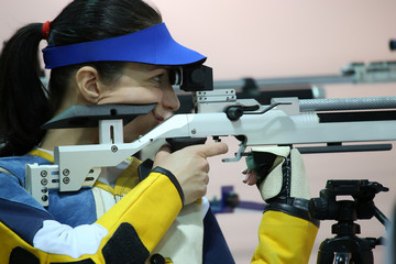 woman aiming a pneumatic air rifle