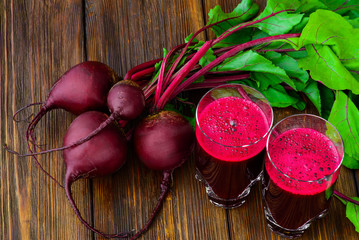 Glass of fresh beetroot juice with bets on wooden table - 85773289