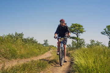 Obraz premium young caucasian cyclists riding in the field