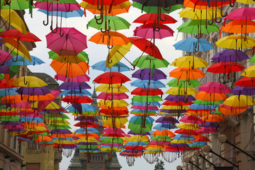Fototapeta na wymiar Ornament with umbrellas and buildings arround in blue sky