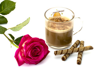 Pink rose and glass of a cappuccino with cookies