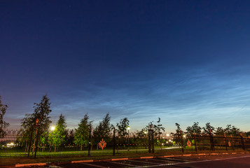 A rare atmospheric phenomenon Noctilucent clouds over the night city 