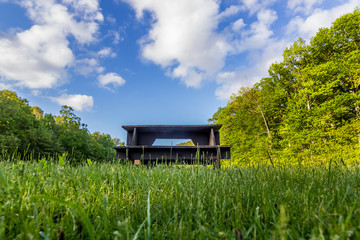 Picnic table sitting in the grass with sky and forest in the background