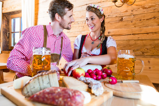 Paar bei Brotzeit auf Bergh&uuml;tte in Alpen