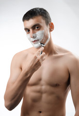 young man shaving with a razor