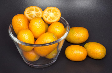 Kumquat fruits (or cumquats) citric fruit on a cup of glass.