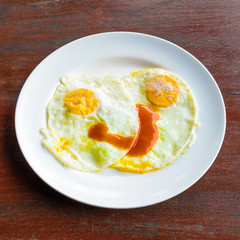 Looks delicious fried eggs on wooden table.