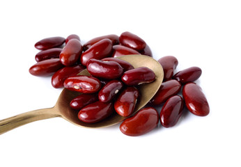 dry red beans in brass spoon on white background