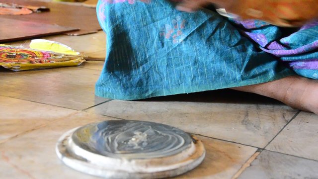 Burmese woman made powder thanaka from ground bark