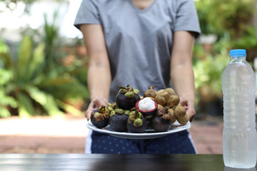 Woman holding plate of fruit  in hands