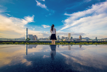 A girl stand in front of Hong Kong city with reflection effect
