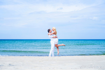 Loving couple walking and embracing on a tropical summer beach