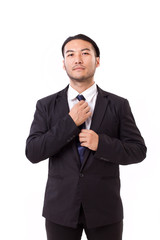 asian businessman fastening his necktie, ready to work