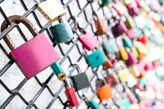 Many love padlocks on fence with selective focus on a blank lock.