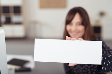 frau im büro zeigt weißes schild