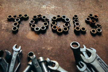 the word Tools written by nuts and a set of wrenches