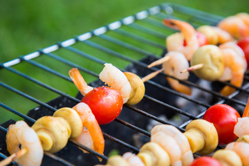 Kebab from shrimps and vegetables on the grill