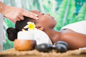 Obraz na płótnie Canvas Attractive woman receiving temple massage at spa center