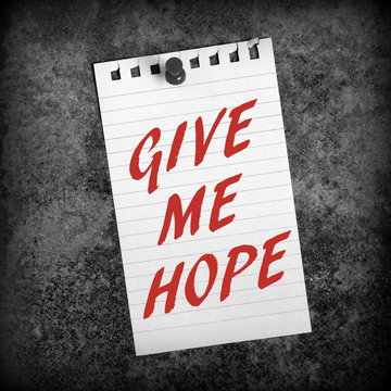 The phrase Give Me Hope in red text on a sheet of lined paper pinned to a grunge background and processed in black and white for effect