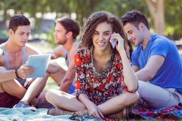 Cute curly hair girl on the phone in the park