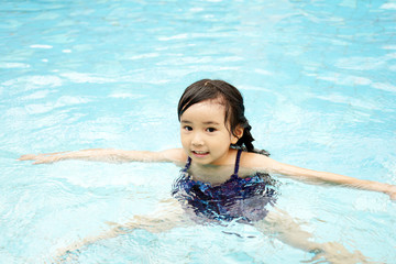 Fototapeta na wymiar プールで遊ぶ笑顔の女の子