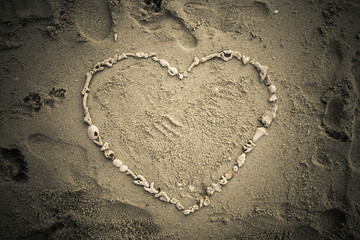 Valentine days background. Heart made by sea shell on sand beach.