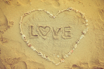 Valentine days background. Heart made by sea shell on sand beach.