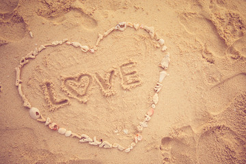 Valentine days background. Heart made by sea shell on sand beach.