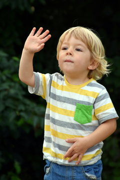 Waving blonde boy