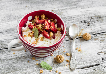 cottage cheese with strawberries and biscuits on a light wooden background