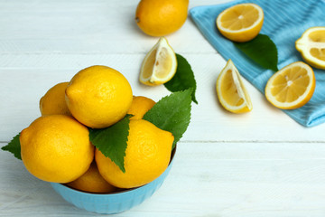 Lemons in a blue bowl on a wooden background