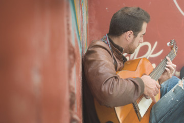 Fototapeta na wymiar man with guitar in a ruined building. urban style