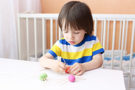 Lovely little boy made toothpick legs by playdough spiders